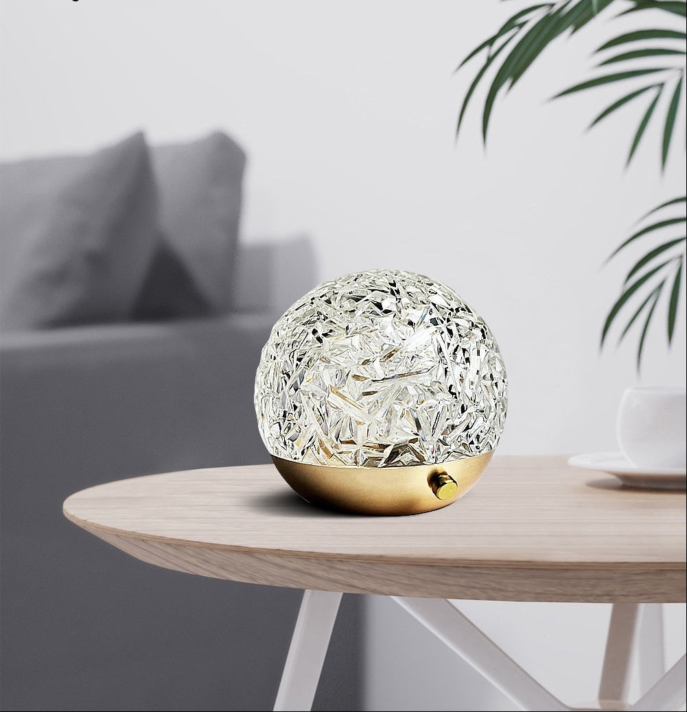 SunGlow sunset lamp on a wooden side table next to a plant